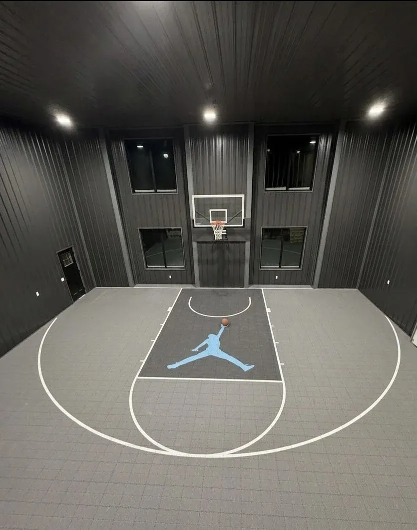 Vantage basketball court installed in a barn, graphite tile with white lines